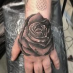 Tattoo mit Rosenmotiv auf dem Handrücken
