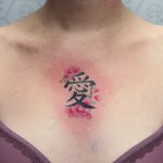 Tattoo mit asiatischem Schriftzeichen und Blüten