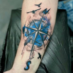 Unterarm Tattoo als Motiv ein Blauer Kompass