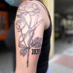 Oberarm Tattoo mit Rosen und Scheren Motiv