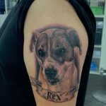 Tattoo mit Hundemotiv und Namensschild im Realistik-Stil