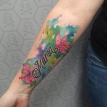 Tattoo im Watercolor-Stil mit dem Wort "Mama" und Blüten