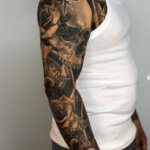 Arm Tattoo mit Totenkopf und Rosen im Realistik-Stil