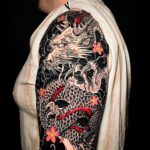 Japanischer Drache auf schwarzem Grund als Arm Tattoo