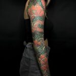 Asiatische Schlange mit Blüten als Tattoo über den ganzen Arm